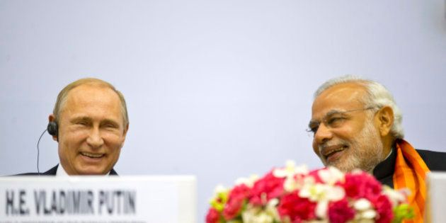 Indian Prime Minister Narendra Modi, right, and Russian President Vladimir Putin share a laugh as they attend a session of the World Diamond Conference in New Delhi, India, Thursday, Dec. 11, 2014. Putin was holding talks with Indian leaders Thursday to strengthen trade and energy cooperation with Asia's third-largest economy as Western sanctions threaten to push his country's economy to the brink of a recession. (AP Photo/ Saurabh Das)