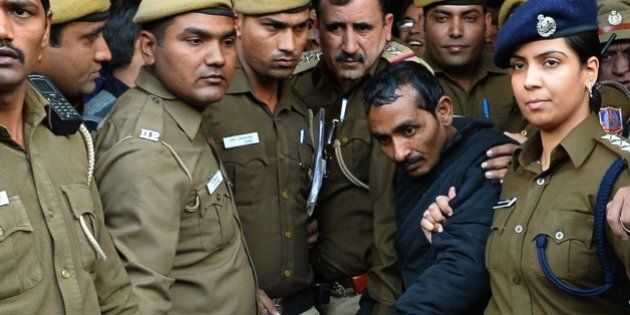 Indian police escort Uber taxi driver and accused rapist Shiv Kumar Yadav (C) following his court appearance in New Delhi on December 8, 2014. Delhi's government on December 8 banned Uber from operating in the Indian capital after a passenger accused one of its drivers of rape, dealing a fresh blow to the reputation of online taxi service. The controversial US-based company has come in for heavy criticism in India since a young company executive said she had been raped by an Uber driver, who had previously been accused of assault. AFP PHOTO / CHANDAN KHANNA (Photo credit should read Chandan Khanna/AFP/Getty Images)