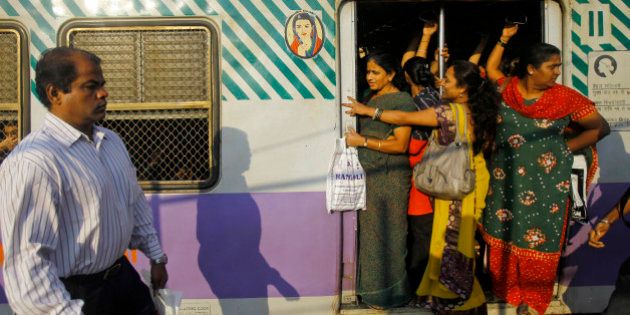 Indian women stand on a door of the ladies compartment of a train as they travel to work early morning in Mumbai, India, Thursday, Jan. 10, 2013. Police badly beat the five suspects arrested in the brutal gang rape and killing of a young woman on a New Delhi bus, the lawyer for one of the men said Thursday, accusing authorities of tampering with evidence in the case that has transfixed India. (AP Photo/Rafiq Maqbool)