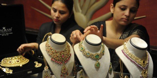 Indian employees display gold jewellery at a jewellery store to mark Dhanteras in Amritsar on October 21, 2014. Dhanteras, which happens two days before the Hindu festival Diwali, is seen as an auspicious day to make purchases. AFP PHOTO/NARINDER NANU (Photo credit should read NARINDER NANU/AFP/Getty Images)