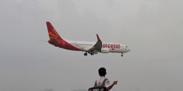 A SpiceJet Ltd. aircraft prepares to land at Chhatrapati Shivaji International Airport in Mumbai, India, on Monday, Sept. 17, 2012. Indiaâs decision allowing airlines to sell stakes of as much as 49 percent to overseas carriers may be most beneficial to operators least in need of investment. Photographer: Dhiraj Singh/Bloomberg via Getty Images