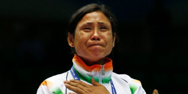 India's L. Sarita Devi cries after she refused her bronze medal during the medal ceremony for the womenâs light 60-kilogram division boxing at the 17th Asian Games in Incheon, South Korea, Wednesday, Oct. 1, 2014. India's protest against the outcome of an Asian Games boxing semifinal that was awarded to South Korea's Park Ji-na over Devi in the women's 60-kilogram division was rejected on Tuesday. Devi rejected her medal in protest against the result. (AP Photo/Kin Cheung)