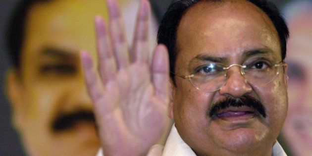 President of the Bharatiya Janata Party (BJP) Venkaiah Naidu gestures at a press conference in Bangalore, India, Sunday, Aug. 22, 2004. Naidu said Sunday that the BJP would first decide on Madhya Pradesh Chief Minster Uma Bharti offer to quit her post and her cabinet colleagues too would accept the party directive, according to news agency reports. In the background is the poster of Naidu. (AP Photo/Gautam Singh)