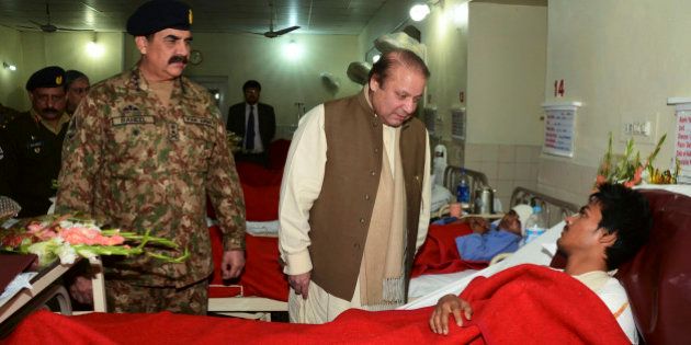 In this picture released by the Inter Services Public Relations, Pakistan's Prime Minister Nawaz Sharif, center, talks to an injured student, a victim of Tuesday's school attack, as Army Chief Gen. Raheel Sharif watches them during their visit to a military hospital in Peshawar, Pakistan, Wednesday, Dec. 17, 2014. The Taliban massacre that killed at least 148 people, mostly children, at a military-run school in northwestern Pakistan left a scene of heart-wrenching devastation, pools of blood and young lives snuffed out as the nation mourned and mass funerals for the victims got underway Wednesday. (AP Photo/Inter Services Public Relations)