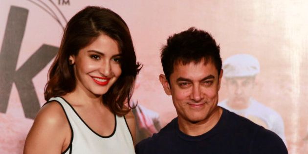 Bollywood actors Aamir Khan, right, and Anushka Sharma pose for photographs during the teaser launch of their upcoming film