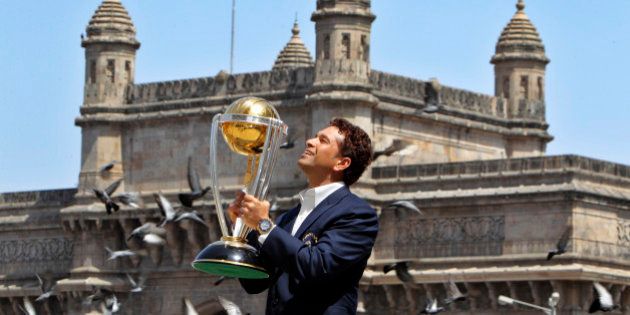 India's Sachin Tendulkar poses with the trophy after winning the Cricket World Cup final match against Sri Lanka in the backdrop of the Gateway of India monument in Mumbai, India, Sunday, April 3, 2011. (AP Photo/Gurinder Osan)