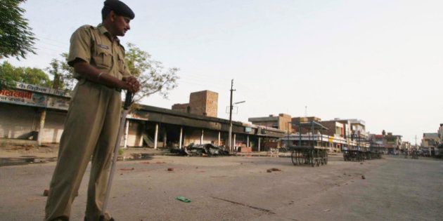A policeman stands guard on a deserted street during a curfew in Dabwali town, Sirsa district, in the Indian state of Haryana, Saturday, July 19, 2008. The curfew was imposed after a clash between a group of Sikhs and supporters of a quasi-religious sect Dera Sacha Sauda left one dead and several injured in Sirsa district Friday. Seeking immediate arrest of the leader of the sect Gurmeet Ram Rahim Singh, radical Sikh organizations Saturday issued a ceasework call in Punjab and Haryana state on July 23. (AP Photo/Davinder Luther)