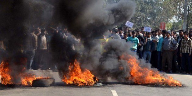 Activists of the Assam Tea Tribes Student Association (ATTSA) block the NH-52 road with burning tyres during a protest against the attacks on villagers by militants from the outlawed National Democratic Front of Bodoland (NDFB) in four locations, at Baghmari in the Sonitpur district of northeastern Assam state on December 24, 2014. At least 56 people including children died in a series of militant attacks in Assam, Indian police said December 24, as the rebels dramatically intensified a long-running separatist campaign in the tea-growing state. AFP PHOTO (Photo credit should read STRDEL/AFP/Getty Images)