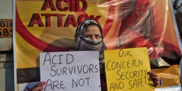 Fareen, a Kashmiri law student holds placards as she participates in protest against an acid attack on a woman in Srinagar, Indian controlled Kashmir, Friday, Dec. 12, 2014. A young woman law student was attacked with acid Thursday that left her in a critical condition, police said. (AP Photo/Dar Yasin)