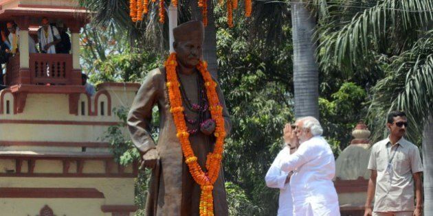 Chief Minister of the Indian state of Gujarat and Bharatiya Janata Party (BJP) prime ministerial candidate Narendra Modi (R) prays in front of a statue of former Hindu nationalist politician Madan Mohan Malviya during a rally in Varanasi on April 24, 2014. India's 814-million-strong electorate is voting in the world's biggest election which is set to sweep the Hindu nationalist opposition to power at a time of low growth, anger about corruption and warnings about religious unrest. AFP PHOTO/STR (Photo credit should read STRDEL/AFP/Getty Images)