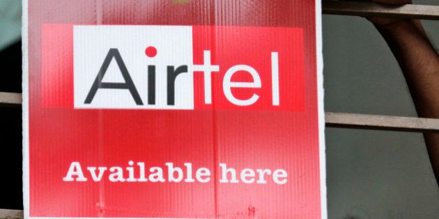 A shopkeeper adjusts an Airtel board outside his shop in Calcutta, India, Wednesday, April 28, 2010. Bharti Airtel, India's largest mobile phone company, suffered lower profits in the January-March quarter as a fierce price war cut into earnings despite growth in subscribers. Net profit fell 8 percent to 20.6 billion rupees ($461.1 million) from the same quarter last year, while revenue grew 2 percent to 100.6 billion rupees ($2.3 billion), the company said Wednesday. (AP Photo/Bikas Das)