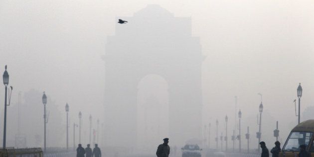 An Indian paramilitary force soldier watches army soldiers rehearse for the Republic Day parade amidst morning fog at India Gate, in New Delhi, India, Tuesday, Jan. 7, 2014. (AP Photo/Tsering Topgyal)