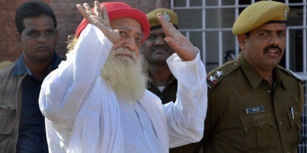 JODHPUR, INDIA - NOVEMBER 18: Asaram Bapu, Hindu preacher gestures to media persons as he returns after being produced at session court in connection with the case of sexual assault of a minor on November 18, 2013 in Jodhpur, India. Court dismissed as withdrawn the petitions moved by controversial self-styled godman Asaram. (Photo by Ramji Vyas/Hindustan Times via Getty Images)