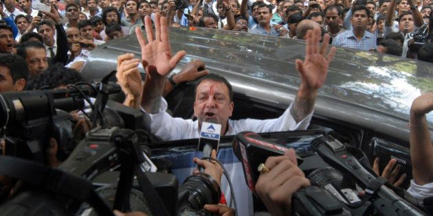 Bollywood star Sanjay Dutt, gestures to the media as he arrives at a court in Mumbai, India, Thursday, May 16, 2013. Dutt has been sentenced to five years in prison for a 1993 weapons conviction linked to a deadly terror attack in Mumbai that killed 257 people. The 53-year-old actor served 18 months in jail before being released on bail in 2007 pending an appeal. The Supreme Court reduced his prison sentence to five years from the six-year term initially handed down. (AP Photo/Rajanish Kakade)
