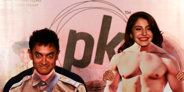 Bollywood actors Aamir Khan, left, and Anushka Sharma pose with movie character cut-outs during the teaser launch of their upcoming film