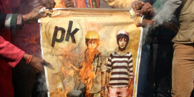BHOPAL, INDIA - DECEMBER 28: Bajrang Dal activists burning the poster of Aamir Khan-starrer film PK outside Jyoti Talkies on December 28, 2014 in Bhopal, India. Accusing Aamir Khan-starrer PK of hurting religious sentiments of the majority community, right-wing outfits accused Aamir Khan-starrer PK of hurting religious sentiments of the majority community demanded a ban on the film. (Photo by Bidesh Manna/Hindustan Times via Getty Images)
