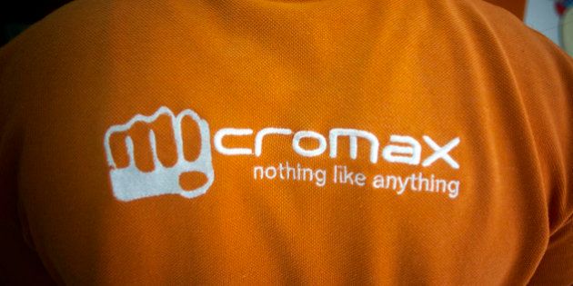 The MicroMax Informatics Ltd. logo is displayed on a employee's shirt at the company's store in New Delhi, India, on Tuesday, April 9, 2013. Apple Inc. and Samsung Electronics Co. are being outpaced in the fast-growing Indian smartphone market by aggressive local competitors Micromax and Karbonn Mobiles India Pvt. Ltd. Photographer: Prashanth Vishwanathan/Bloomberg via Getty Images