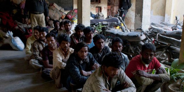 Indian fishermen sit at a police station in Karachi, Pakistan, Thursday, Dec. 11, 2104. Pakistan's coast guard arrested 58 Indian fishermen over encroaching into Pakistani waters, official said. (AP Photo/Shakil Adil)