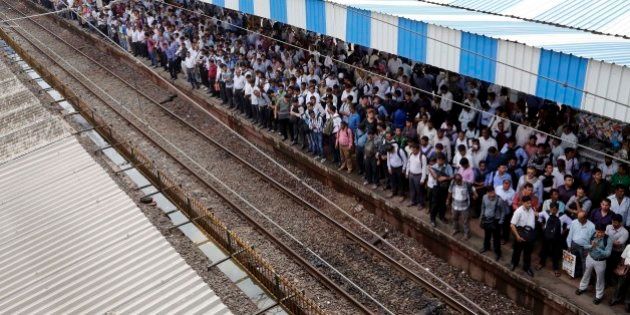 Commuters wait for local trains in Mumbai, India, Tuesday, July 8, 2014. India's new rail minister Sadananda Gowda on Tuesday proposed allowing foreign investment to modernize the country's cash-strapped state railways. India has one of the world's largest railways, which transports 23 million passengers a day. Indian Railways is one of the world's biggest employers with more than 1.3 million employees. The network lost 300 billion rupees ($5 billion) last year. (AP Photo/Rajanish Kakade)