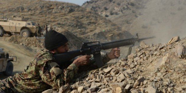 In this picture taken on January 3, 2015, an Afghan National Army (ANA) soldier fires during an ongoing anti-Taliban operation in Dangam district near the Pakistan-Afghanistan border in the eastern Kunar province. Afghan security forces have launched a joint anti-militant operations in several parts of Dangam district of Kunar province. So far in the operation, 157 armed insurgents have been killed and 112 others wounded, seven security personnel killed and six others were wounded in the past 25 days, police chief Abdul Habib SyedKhalil said. AFP PHOTO / Noorullah Shirzada (Photo credit should read Noorullah Shirzada/AFP/Getty Images)