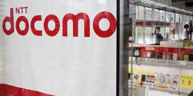 The NTT Docomo Inc. logo is displayed in the window of one of the company's stores in Tokyo, Japan, on Tuesday, June 10, 2014. NTT Docomo, Japan's largest wireless carrier by subscribers, began offering Apple Inc's iPad today. Photographer: Tomohiro Ohsumi/Bloomberg via Getty Images