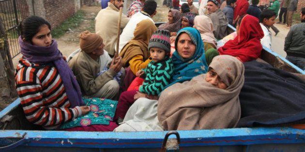 Indian villagers sit in the back of a vehicle as they flee their homes fearing firing from the Pakistan side of the border at Bainglad village in Samba sector, about 52 Kilometers from Jammu, India, Saturday, Jan. 3, 2015. Pakistani and Indian border guards traded artillery fire along the disputed border region of Kashmir, killing two people and wounding eight, officials said Saturday. (AP Photo/Channi Anand)