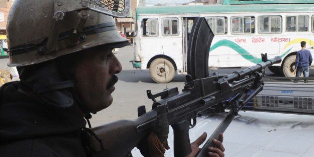 An Indian police personnel stands guard (L) during a protest against the death sentence of Balwant Singh Rajoana in the Beant Singh assassination case, in Amritsar on March 28, 2012. A court has ordered that Rajona be hanged on March 31 inspite of mercy appeals coming before India's President Pratibha Singh Patil, sparking of protest by sikh supporters throughout Punjab and elsewhere in the country. Rajoana was sentenced to death in 2007 for his role in the 1995 assassination of the then Punjab chief minister, Beant Singh. AFP PHOTO/NARINDER NANU (Photo credit should read NARINDER NANU/AFP/Getty Images)