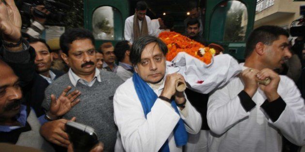 NEW DELHI, INDIA - JANUARY 18: Congress leader Shashi Tharoor (C) and relatives and friends carry the body of Tharoor's wife Sunanda Pushkar before her cremation at Lodhi Road crematorium, South Delhi, on January 18, 2014 in New Delhi, India. The wife of Indian Minister Shashi Tharoor, found dead in a luxury hotel after accusing her husband of being unfaithful, suffered an 'unnatural, sudden death', a doctor who performed an autopsy on her body said. Sunanda and Tharoor relation was disturbed as she was upset over reported text and tweet messages between her husband and Pakistani journalist Mehr Tarar. (Photograph by Raj k Raj/ Hindustan Times via Getty Images)