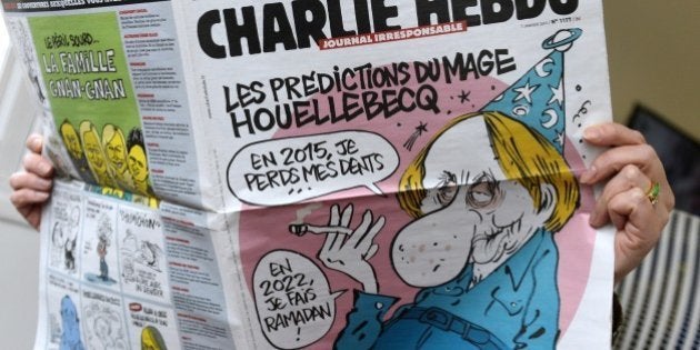 A person reads the latest issue of the French satirical newspaper Charlie Hebdo in Paris on January 7,...