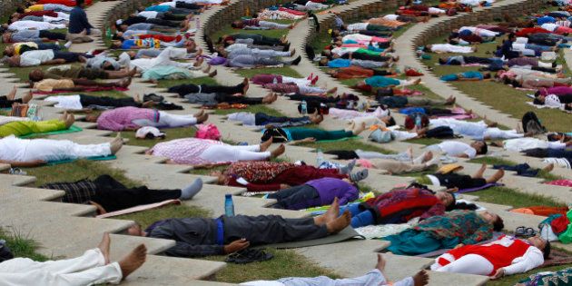 Yoga enthusiasts lie down after performing Surya Namaskar or sun salutation during