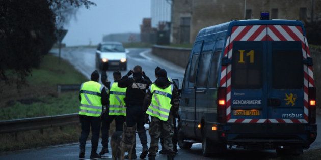 LONGPONT, FRANCE - JANUARY 09: Police officers stop a car at a check point on January 9, 2015 outside Longpont, France. A huge manhunt for the two suspected gunmen in Wednesday's deadly attack on Charlie Hebdo magazine has entered its third day. (Photo by Pascal Le Segretain/Getty Images)