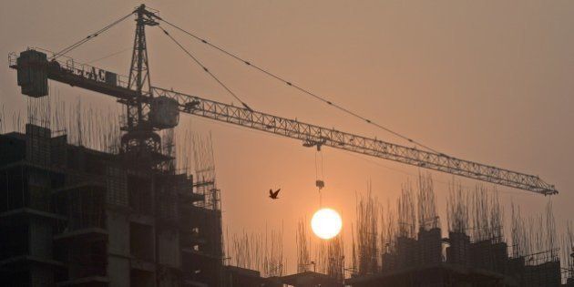 Sun rises over an under-construction apartment building on the outskirts of New Delhi early November 7, 2014. In the first Japanese entry into the Indian property market, Tama Homes announced November 5, the construction of 12-18 projects at an investment of some 975 million USD in partnership with Singapore's Developer Group, will jointly build three housing projects, including two townships, having about 3,500 housing units, in Ludhiana, Visakhapatnam and Chennai. AFP PHOTO/ Prakash SINGH (Photo credit should read PRAKASH SINGH/AFP/Getty Images)