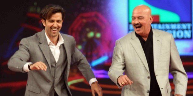 Indian Bollywood actor Hrithik Roshan (L) and his father Rakesh Roshan dance during the annual 'Umang 2015 Mumbai Police Show' in Mumbai on late January 10, 2015. AFP PHOTO / STR (Photo credit should read STRDEL/AFP/Getty Images)