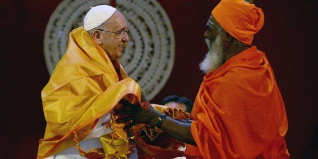 Pope Francis (L) receives a shawl as a gift from Sri Lankan Hindu priest Kurukkal SivaSri T Mahadeva during an inter-religious meeting in the Bandaranaike Memorial International Conference Hall in Colombo on January 13, 2015. Pope Francis urged respect for human rights in Sri Lanka as he began a two-nation Asia tour on the island, bearing a message of peace and reconciliation after a long civil war. AFP PHOTO / Munir uz ZAMAN (Photo credit should read MUNIR UZ ZAMAN/AFP/Getty Images)