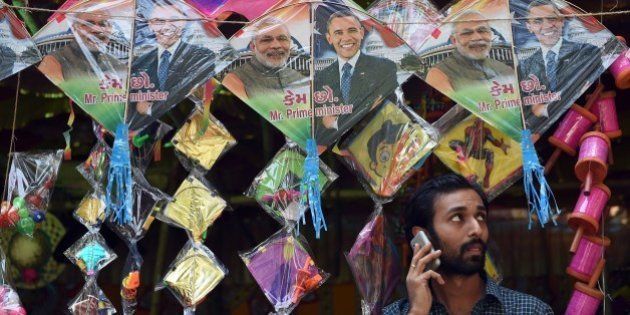 An Indian shopkeeper talks on his mobile phone below kites with images of Indian prime minister Narendra Modi (L) and US President Barack Obama (R) in Mumbai on January 7, 2015. Obama travels to India as chief guest for the January 26, Republic Day celebrations and talks with Prime Minister Narendra Modi. Modi has been courted by the United States as a key partner in its attempt to rebalance US diplomatic weight toward Asia. AFP PHOTO / INDRANIL MUKHERJEE (Photo credit should read INDRANIL MUKHERJEE/AFP/Getty Images)
