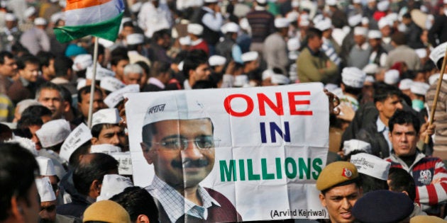 NEW DELHI, INDIA - DECEMBER 28: Supporters of the Aam Aadmi (Common Man) Party watch their unseen leader Arvind Kejriwal taking his oath of office as Chief Minister of Delhi from Delhi's Lt. Governor Najeeb Jung during swearing-in ceremony at Ramlila Ground on December 28, 2013 in New Delhi, India. Kejriwal's upstart Aam Aadmi Party made a stunning electoral debut, winning 28 assembly seats in recent state polls and delivering a stinging defeat to the Congress party which rules at the national level. (Photo by Raj K Raj/Hindustan Times via Getty Images)