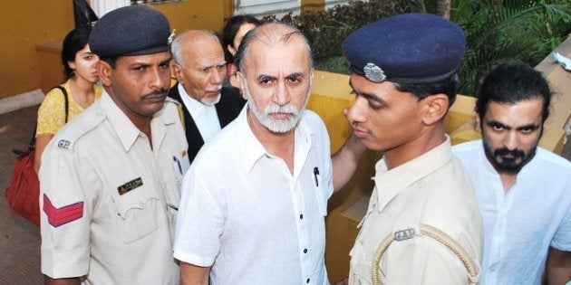 Indian magazine editor Tarun Tejpal (C) is escorted by police officials after a hearing at The High Court in Goa on March 4, 2014. Tarun Tejpal, the founder and editor of top investigative magazine Tehelka, has been in custody since his arrest in late November 2013, over an alleged incident of rape in a hotel lift in the southern holiday state -- a case that has scandalised the Indian media. AFP PHOTO/STR (Photo credit should read STRDEL/AFP/Getty Images)