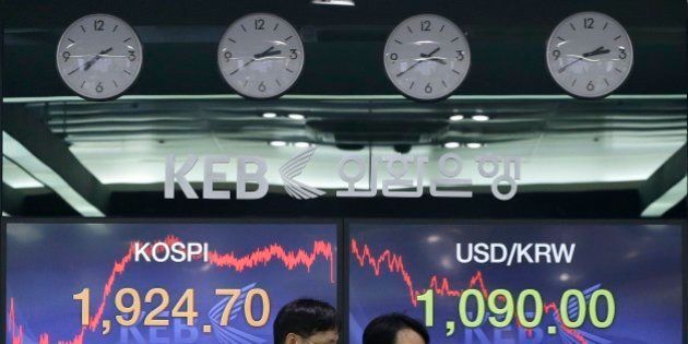 Currency traders pass by screens showing the Korea Composite Stock Price Index (KOSPI) and foreign exchange rate, right, at the foreign exchange dealing room of the Korea Exchange Bank headquarters in Seoul, South Korea, Friday, Jan. 9, 2015. Asian stocks extended gains Friday after other global markets bounced back from a rocky start to the year and oil prices stabilized after dramatic plunges. The Korea Composite Stock Price Index rose 1.05 percent, or 20.05, to close at 1,924.70. (AP Photo/Ahn Young-joon)