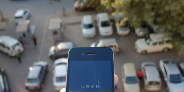 The Uber smartphone app, used to book taxis using its service, is pictured over a parking lot in the Indian capital New Delhi on December 7, 2014. An Uber taxi driver allegedly raped a 25-year-old passenger in the Indian capital before threatening to kill her, police said December 7, in a blow to the company's safety-conscious image. AFP PHOTO/TENGKU BAHAR (Photo credit should read TENGKU BAHAR/AFP/Getty Images)