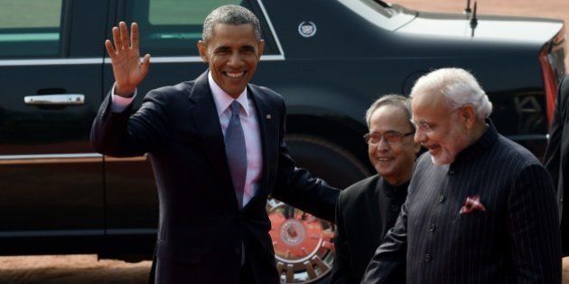 US President Barack Obama (L) waves as Indian President Pranab Mukherjee (C) and Indian Prime Minister Narendra Modi (R) look on as he leaves following a welcome ceremony at the Presidential Palace in New Delhi on January 25, 2015. US President Barack Obama began a landmark visit to India on January 25 with a bear hug from Prime Minister Narendra Modi, signalling a new warmth in a sometimes strained relationship. AFP PHOTO/Roberto SCHMIDT (Photo credit should read ROBERTO SCHMIDT/AFP/Getty Images)