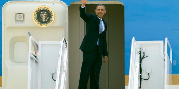 President Barack Obama waves as he boards Air Force One at Andrews Air Force Base, Md. Tuesday, April 22, 2014, for a flight to Oso, Washington to visit with victims of the deadly March 22 disaster, emergency responders and recovery workers. (AP Photo/Cliff Owen)