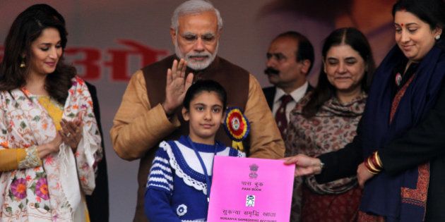 PANIPAT, INDIA - JANUARY 22: Prime Minister Narendra Modi along with film actress Madhuri Dixit, Union Minister for Women and Child Development Maneka Gandhi and HRD Minister Smriti Irani present Sukanya Samriddhi account pass-book to a girl at launch of Beti Bachao Beti Padhao programme on January 22, 2015 in Panipat, India. The Beti Bachao Beti Padhao campaign, which means Save the girl child, educate the girl child, aims to address the issue of declining Child Sex Ratio (CSR) through a mass campaign across the country targeted at changing societal mindsets and creating awareness about the criticality of the issue. (Photo by Ravi Kumar/Hindustan Times via Getty Images)