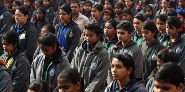 Indian schoolchildren pray during an assembly at their school in New Delhi on December 17, 2014, as they pay tribute to slain Pakistani schoolchildren and staff after an attack on an army-run school in the restive city of Peshawar. Pakistan began three days of mourning on December 17 for the 132 schoolchildren and nine staff killed by the Taliban in the country's deadliest ever terror attack as the world united in a chorus of revulsion. The 141 people were killed when insurgents stormed an army-run school in the northwestern city of Peshawar and systematically went from room to room shooting children during an eight-hour killing spree. AFP PHOTO / SAJJAD HUSSAIN (Photo credit should read SAJJAD HUSSAIN/AFP/Getty Images)