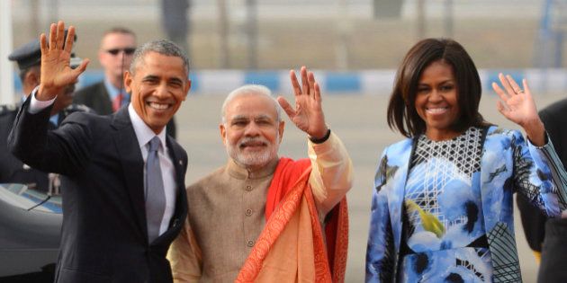 Indian Prime Minister Narendra Modi, center, U.S. President Barack Obama and first lady Michelle Obama wave to the gathering at the Palam Air Force Station in New Delhi, India, Sunday, Jan. 25, 2015. Obama's arrival Sunday morning in the bustling capital of New Delhi marked the first time an American leader has visited India twice during his presidency. Obama is also the first to be invited to attend India's Republic Day festivities, which commence Monday and mark the anniversary of the enactment of the country's democratic constitution. (AP Photo)