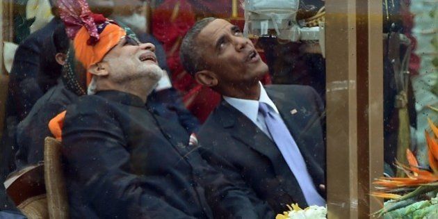 Indian Prime Minister Narendra Modi (L) talks with US President Barack Obama (R) while watching the fly-past during India's Republic Day parade on Rajpath in New Delhi on January 26, 2015. Rain failed to dampen spirits at India's Republic Day parade January 26 as Barack Obama became the first US president to attend the spectacular military and cultural display in a mark of the nations' growing closeness. AFP PHOTO/ PRAKASH SINGH (Photo credit should read PRAKASH SINGH/AFP/Getty Images)