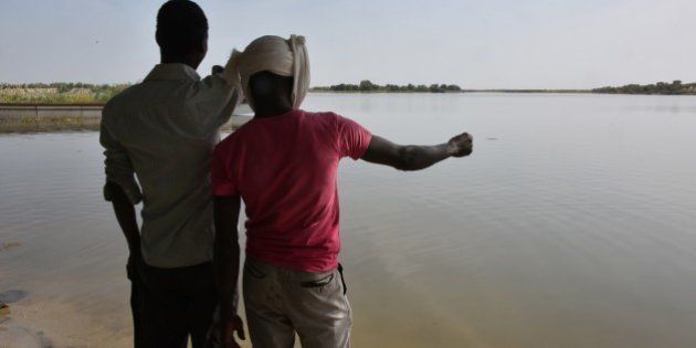 A survivor of a Boko Haram's attack and his friend look at the waters of Lake Chad which borders Chad, Nigeria, Niger and Cameroon, in Bol on January 25, 2015. Chad's President Idriss Deby has secured control of regional operations against Boko Haram Islamists, riding roughshod over his supposed allies in a week-long diplomatic and military offensive. There have been months of disagreements between the countries directly threatened by Boko Haram -- Nigeria, Cameroon, Chad and Niger -- on exactly how to take on the Islamists. AFP PHOTO / SIA KAMBOU (Photo credit should read SIA KAMBOU/AFP/Getty Images)