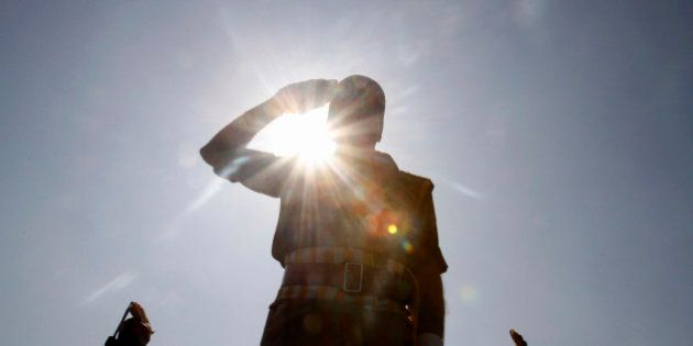 A Jammu and Kashmir state police officer salutes during a function to mark Police Commemoration Day, on the outskirts of Srinagar, India, Monday, Oct. 21, 2013. The annual Police Commemoration Day is being observed Monday to remember and pay respect to fallen policemen in the troubled Kashmir region. More than a dozen militant groups have been fighting since 1989 seeking independence for Kashmir or its merger with neighboring Pakistan, where at least 68,000 people, most of them civilians, have died in the 24th year of conflict. (AP Photo/Mukhtar Khan)