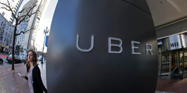 In this Tuesday, Dec. 16, 2014 photo, a woman leaves the headquarters of Uber in San Francisco. Venture capitalists poured a whopping $48.3 billion into U.S. startup companies last year, investing at levels that haven't been seen since before the dot-com bubble burst in 2001, according to a new report issued Friday, Jan. 16, 2015. The two biggest deals in 2014 were separate rounds of investment in Uber Technologies, the high-flying and controversial ride-hailing service, now valued at $41 billion. (AP Photo/Eric Risberg)