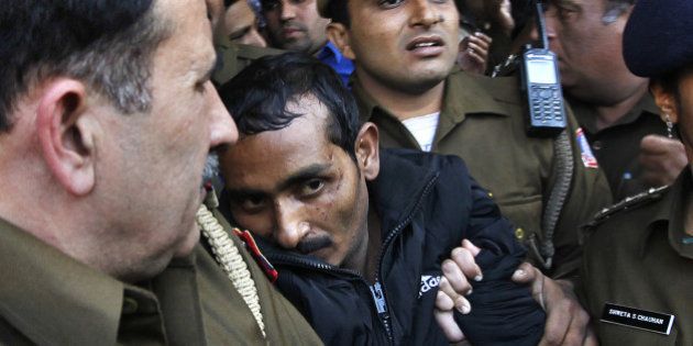 NEW DELHI, INDIA DECEMBER 8: Police escort Uber cab driver Shiv Kumar Yadav (C, in black) who is accused of raping a woman, following his court appearance at the Tis Hazari court on December 8, 2014 in New Delhi, India. Shiv Kumar Yadav was remanded in custody for three days while police investigates the case. Delhi government banned Uber from operating in the Indian capital for failing to do background check on Shiv Kumar, who had previously been accused of assault. (Photo by Raj K Raj/Hindustan Times via Getty Images)