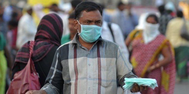An Indian vendor sells face masks for swine flu prevention outside a railway station in Secunderabad on January 27, 2015. Twenty two swine flu deaths have been recorded since January with more than 440 positive cases in the southern Indian state of Telangana, according to a report. AFP PHOTO / Noah SEELAM (Photo credit should read NOAH SEELAM/AFP/Getty Images)